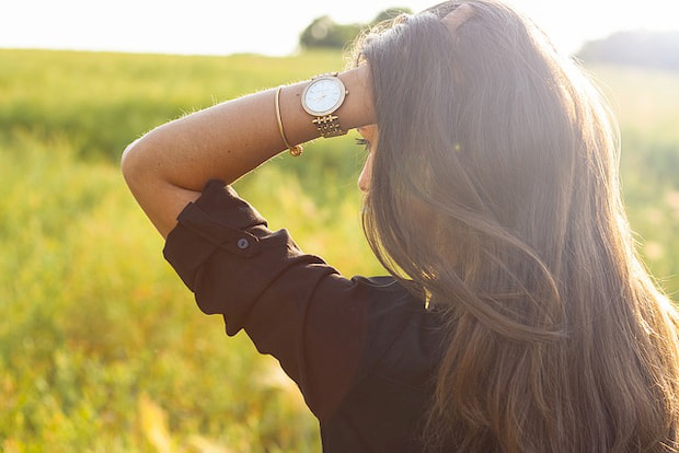 Woman with a watch in a field.