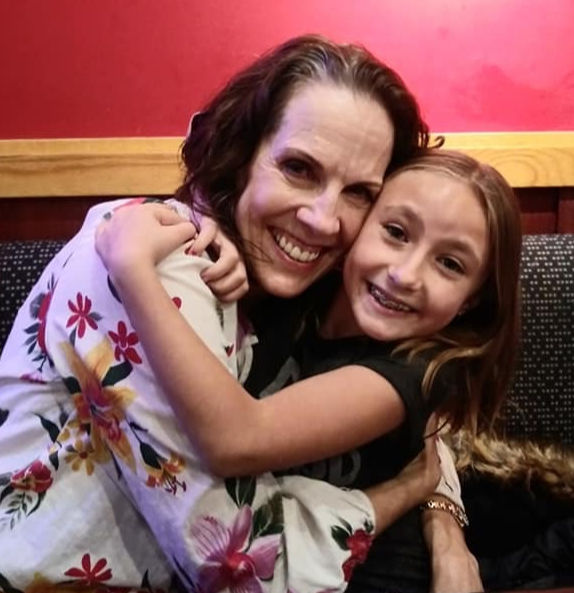 Grandmother and granddaughter hugging.