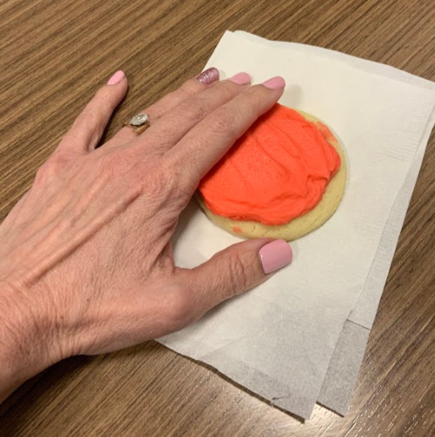 A manicured hand holding a cookie.