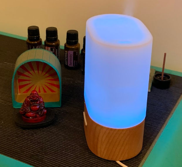 Small Buddha statue, essential oils, and diffuser.