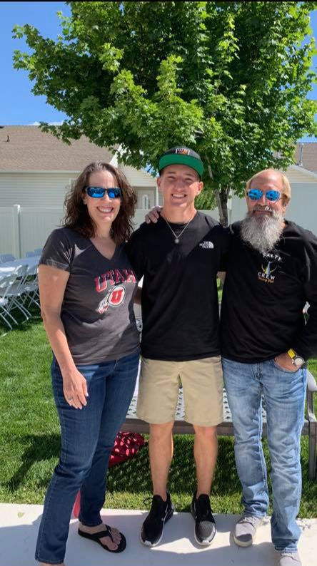 High school graduate with his grandparents.