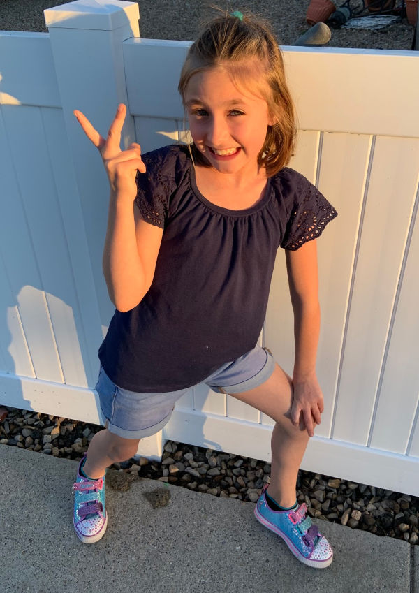 Young girl flashing the peace sign.