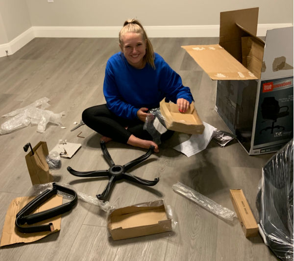 Teenage girl putting an office chair together.