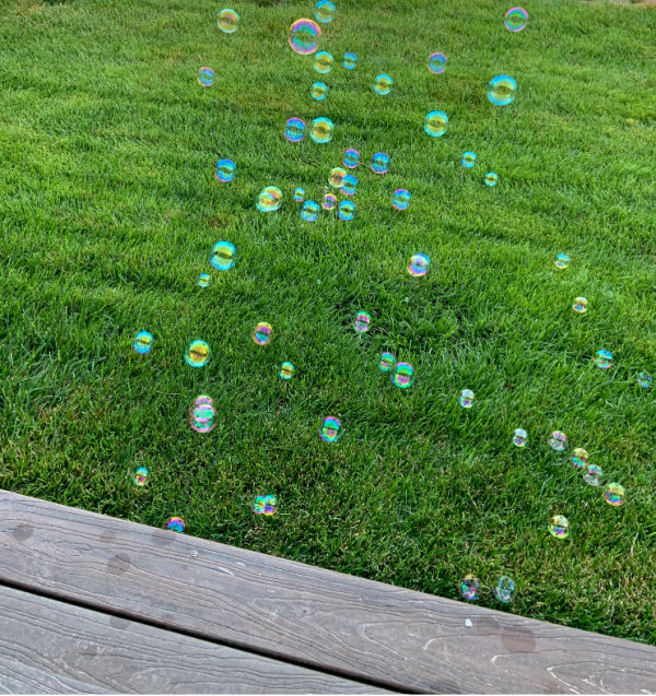 Bubbles floating over green grass.