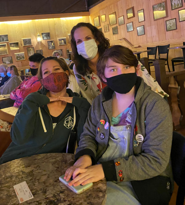 Three women with protective face masks in a theater.