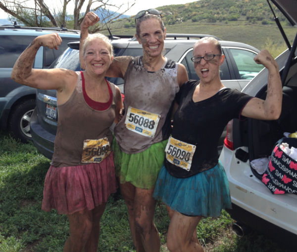 Three ladies in tutus covered in mud.