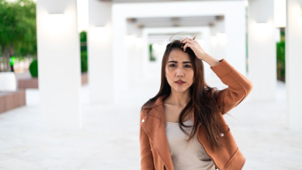 Woman touching her scalp.