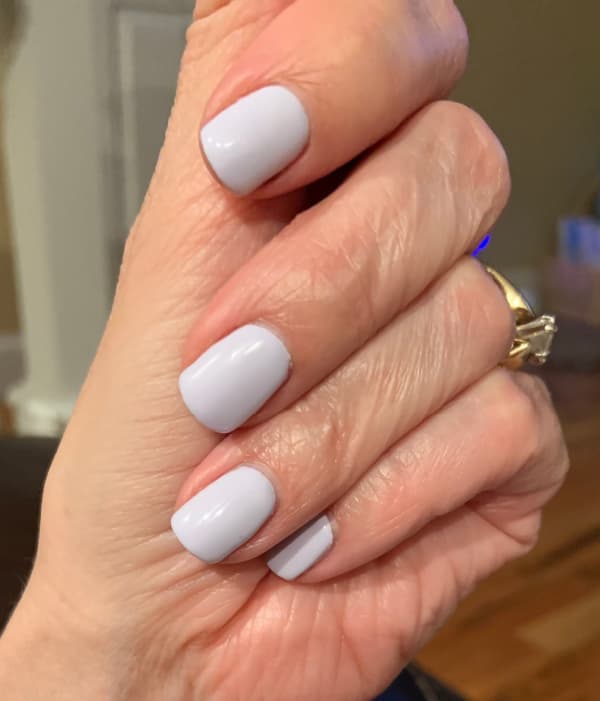 Light lilac nail polish on a woman's hand.