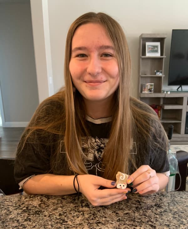 Teenage girl holding a painted rock.