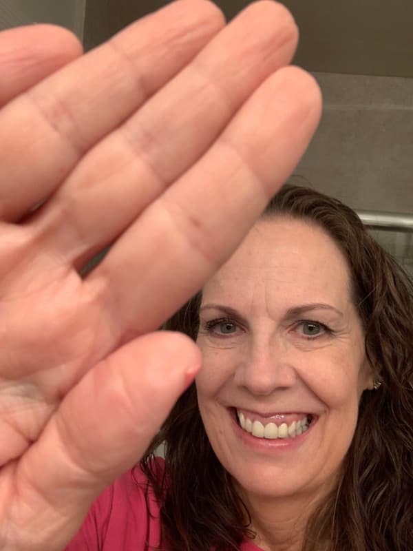 Close up of woman high-fiving the camera.