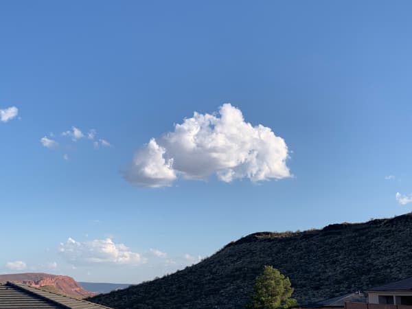 A fluffy white cloud in the blue sky.