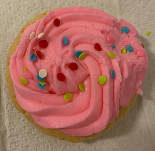 Sugar cookie with pink frosting and sprinkles.