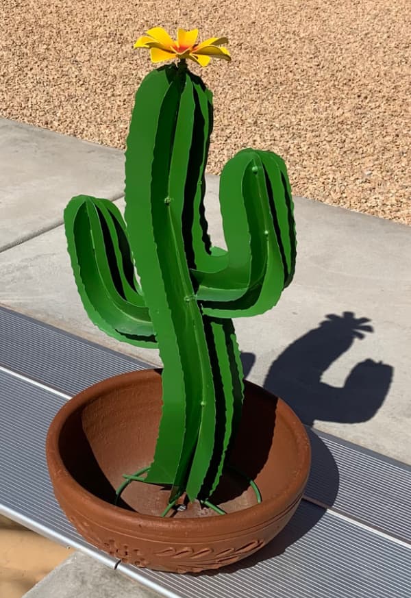 Painted metal cactus with a yellow flower on top.