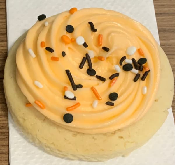 Orange sugar cookie with sprinkles.