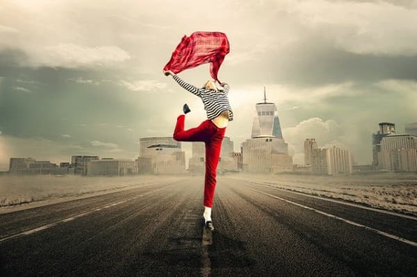 A woman leaping with joy in the street.