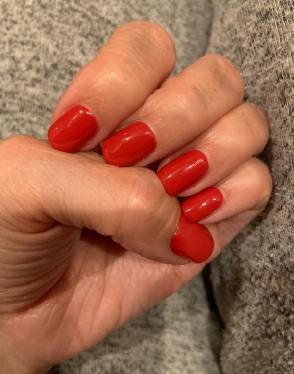 Female hand with red nail polish.