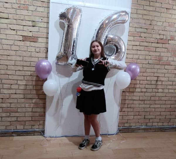 Sixteen year old girl with balloons on her birthday.