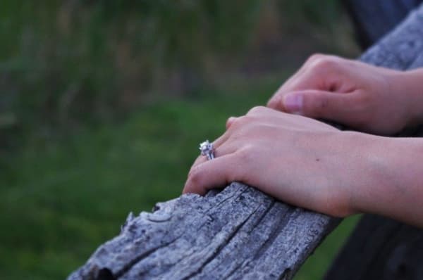 A woman's hands wearing an engagement ring.