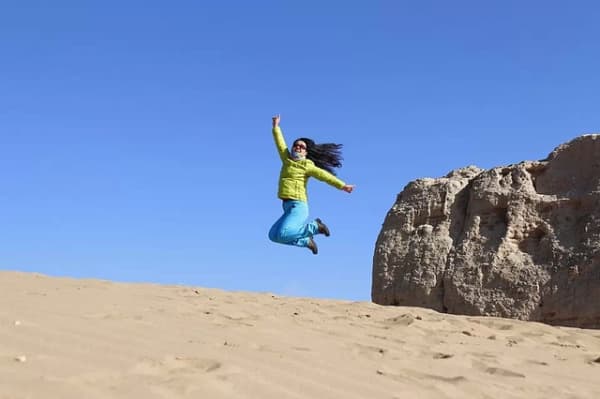 Woman leaping in a desert.