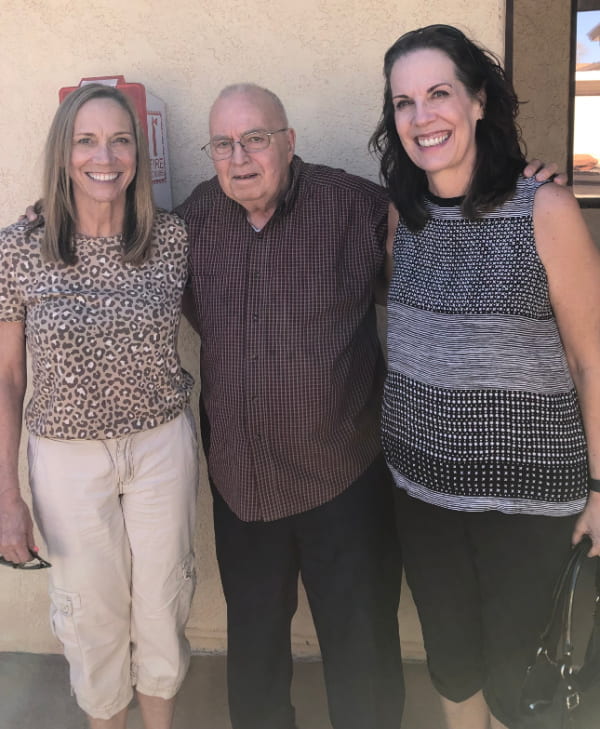An elderly man and his two adult daughters.