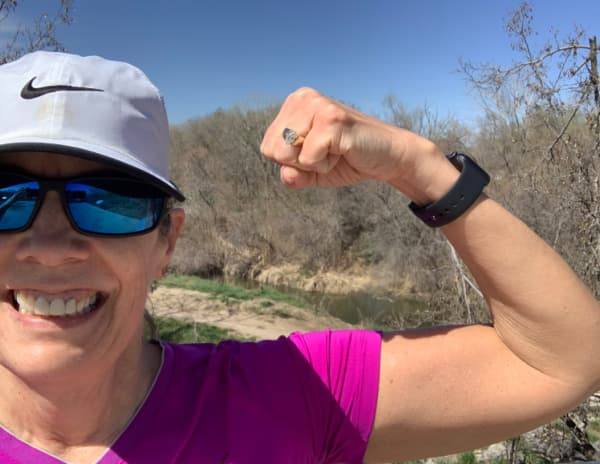 Woman flexing her muscles on a hike.