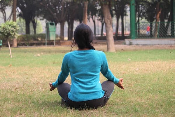 Woman meditating outdoors.