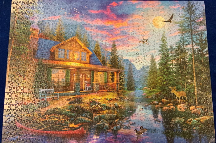 Completed jigsaw puzzle of a country cabin.