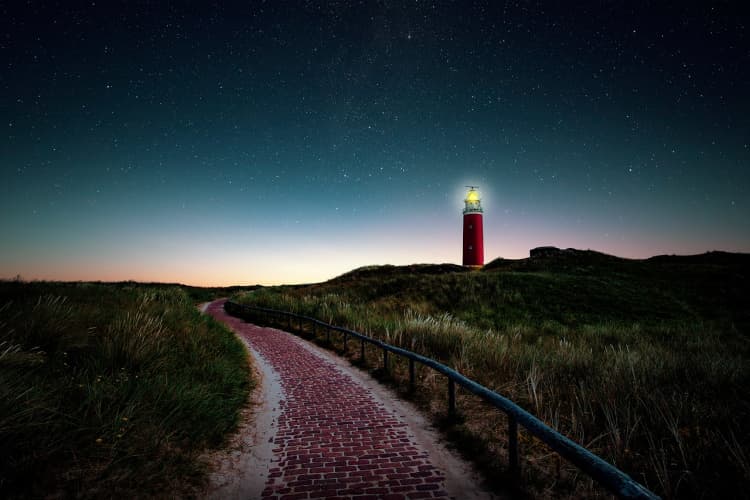A brick path leading to a lighthouse.