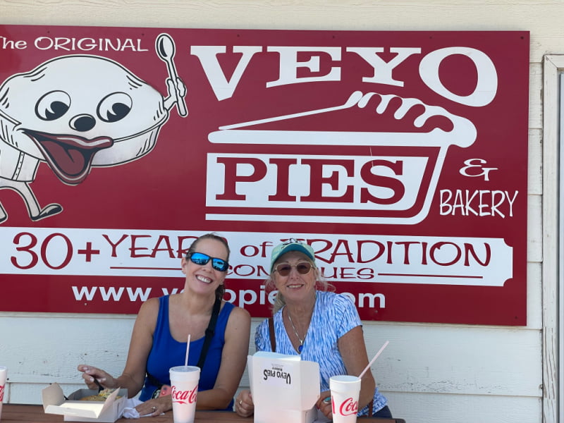 Two women in front of the Veyo Pies & Bakery sign.