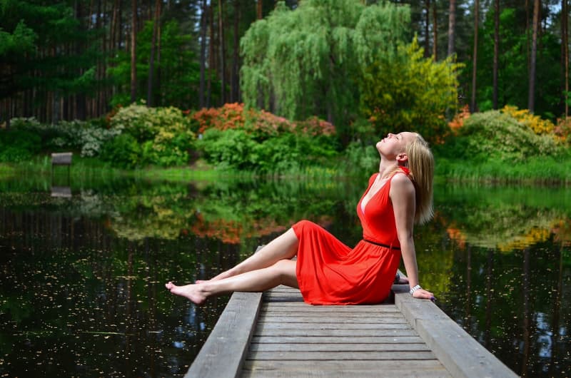 Lady in red dress on a dock.