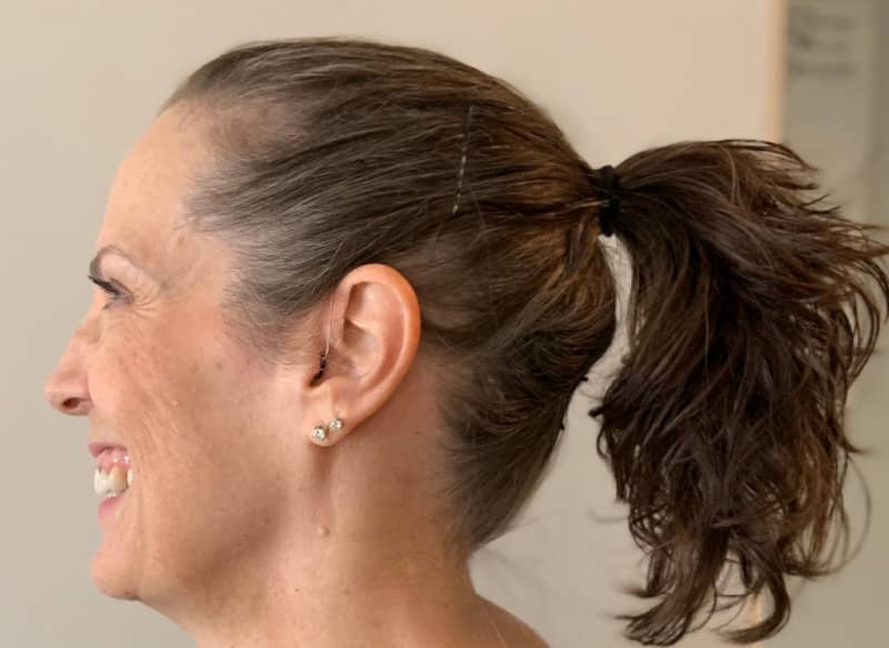 Side view of a woman wearing hearing aids.