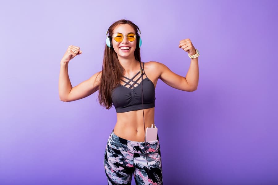 Woman listening to music and flexing muscles.