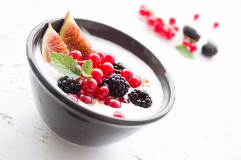 Bowl of yogurt with fruit in it.