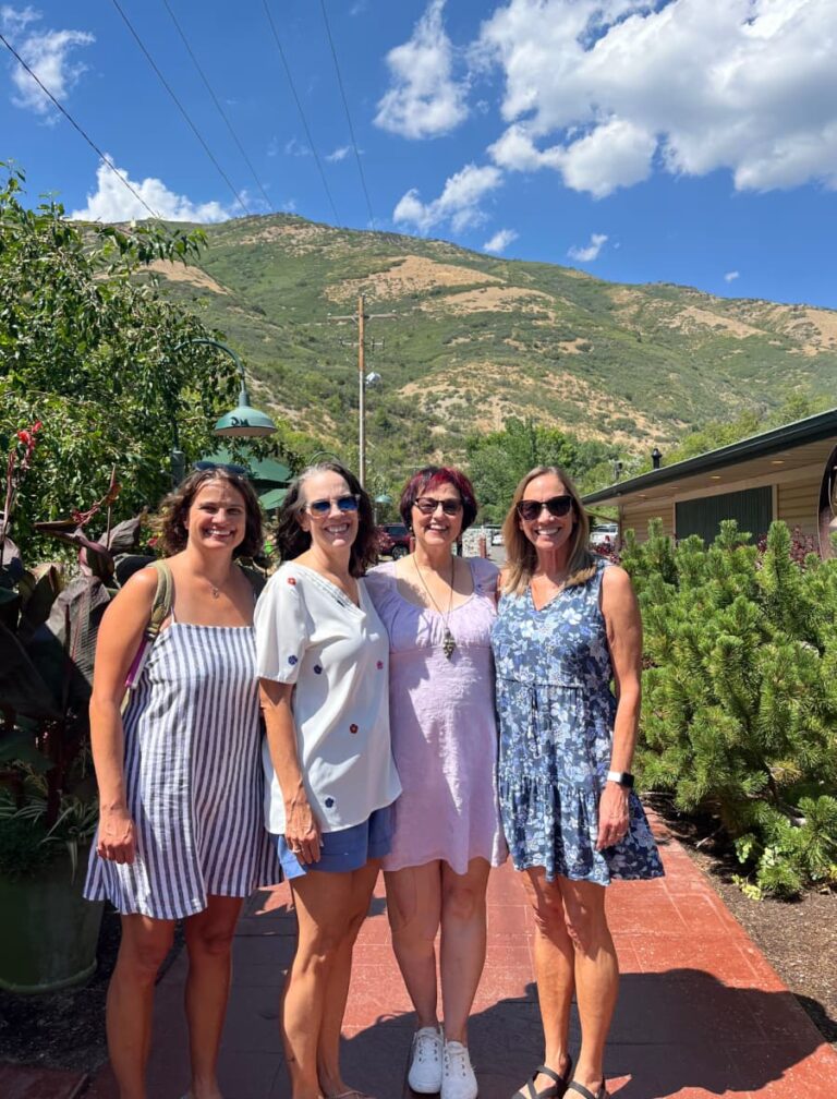 Four adult sisters with a mountain in the background.
