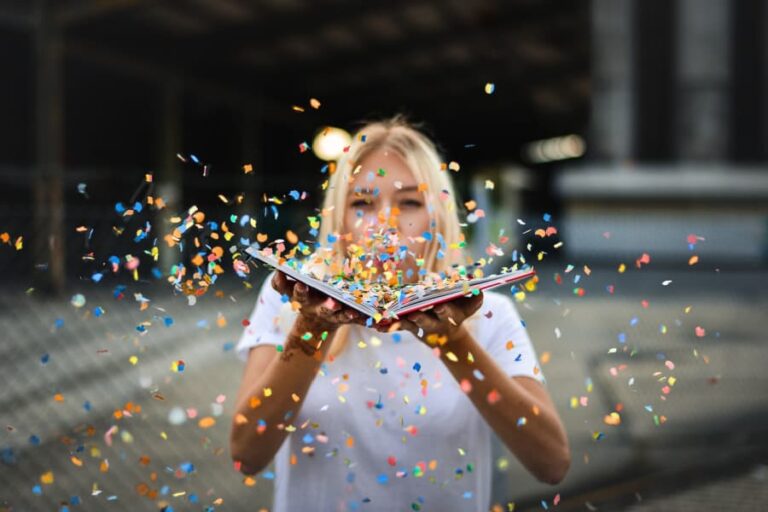 Woman blowing confetti.