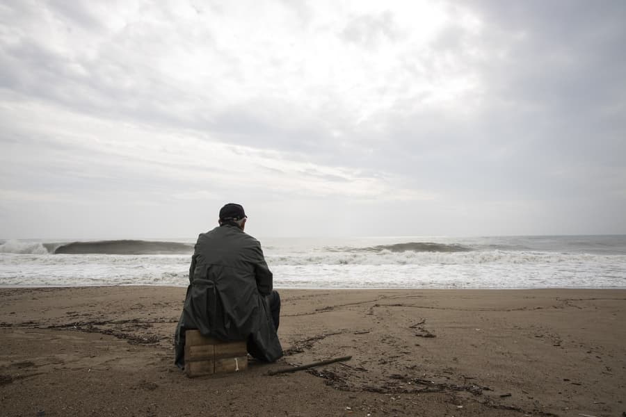 Man sitting on the beach in a storm.