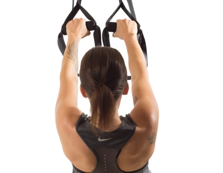 Woman working out with TRX straps.