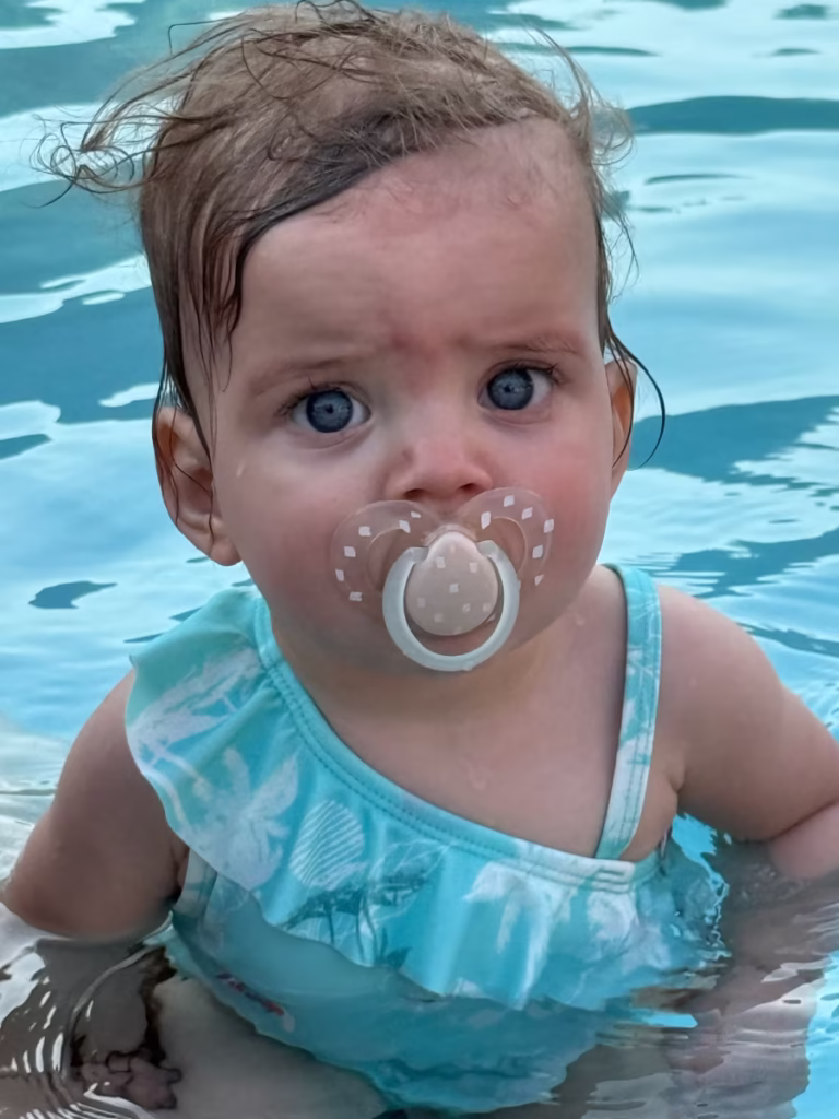 A baby girl in a swimming pool.