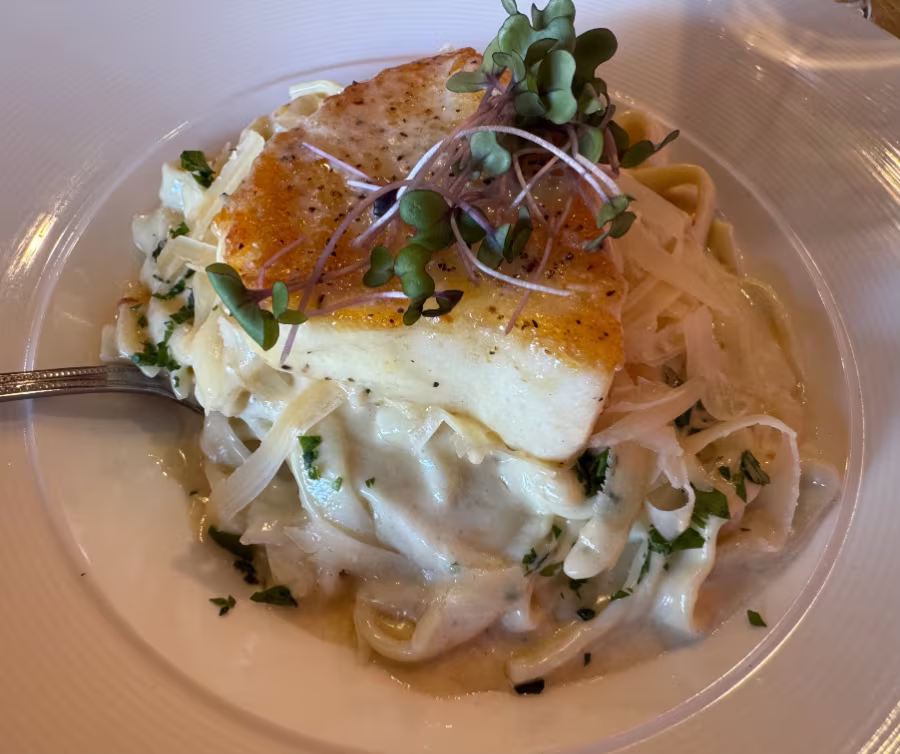 Sea bass on pasta with cream sauce.