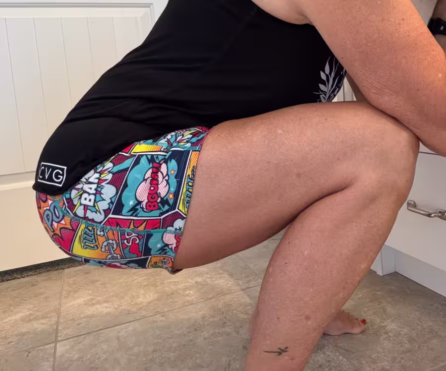 Woman squatting in CVG Knockout shorts.