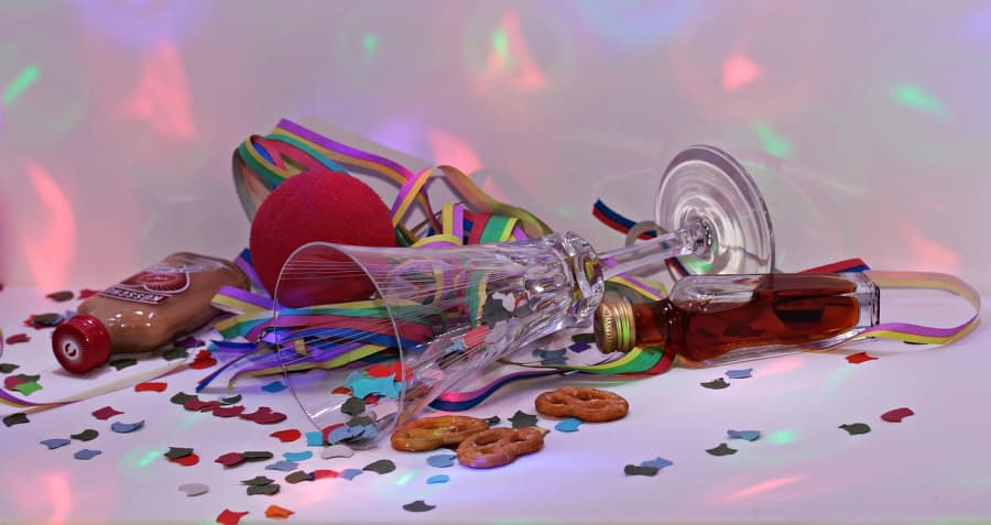 Party trappings: glass, alcohol, confetti, and streamers.
