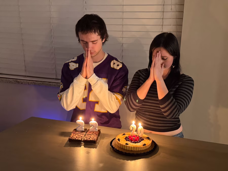 Young adults blowing candles out on birthday cakes.
