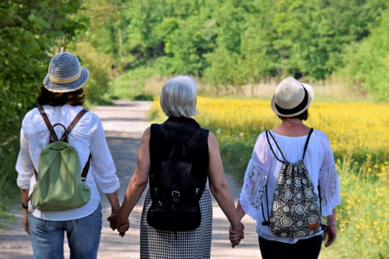 Three midlife women holding hands.