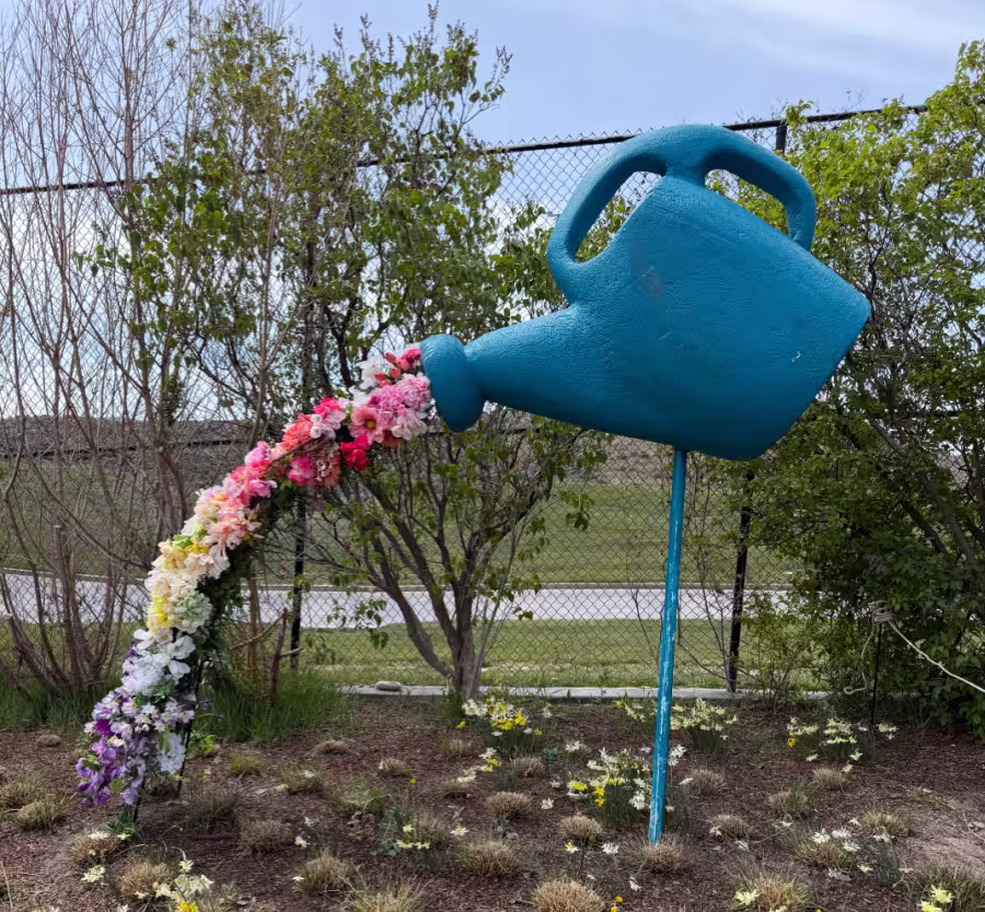 A water can and flowers made of tulips.