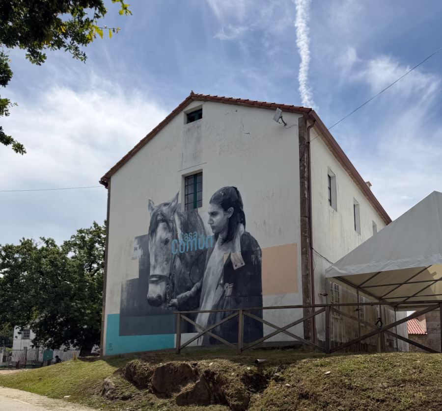 A mural depicting a woman and a horse on the side of a building.