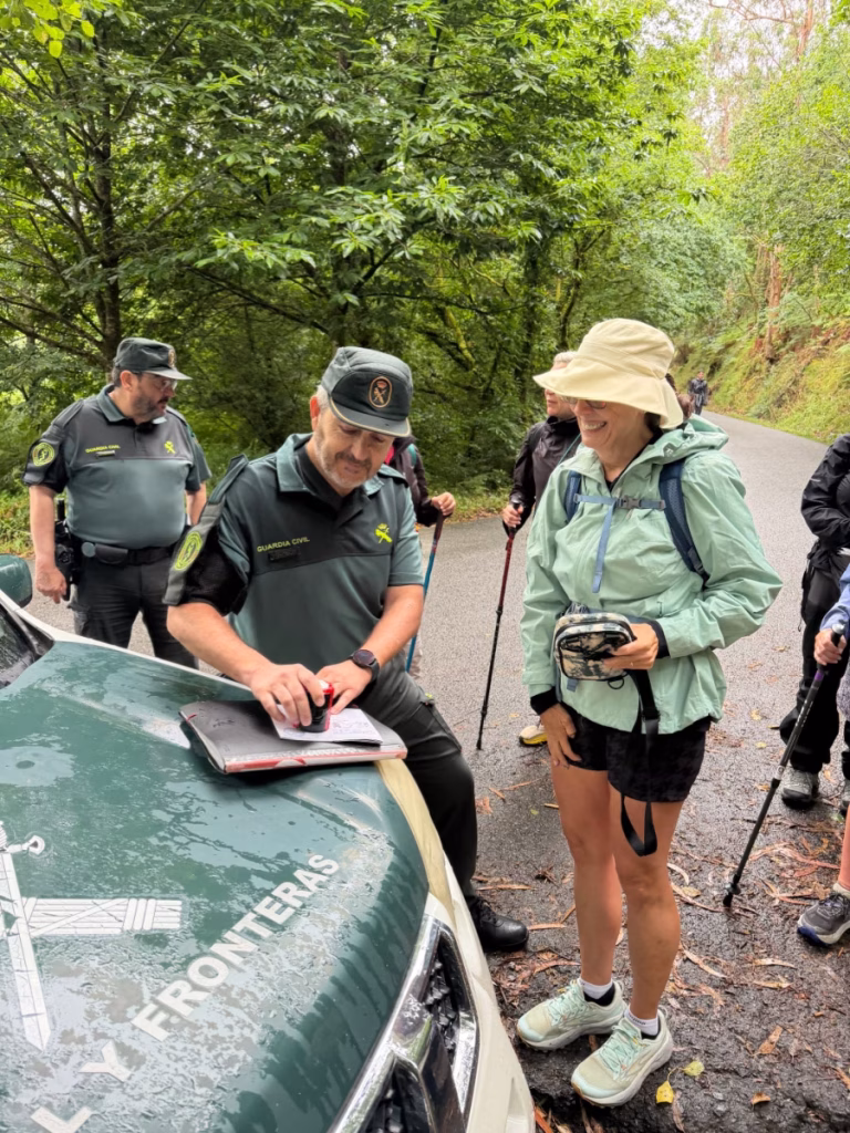Law enforcement officer giving a Camino pilgrim a stamp.