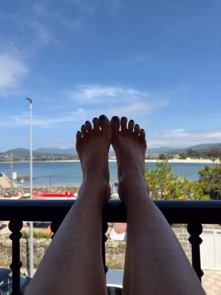Feet up on a balcony overlooking the ocean.