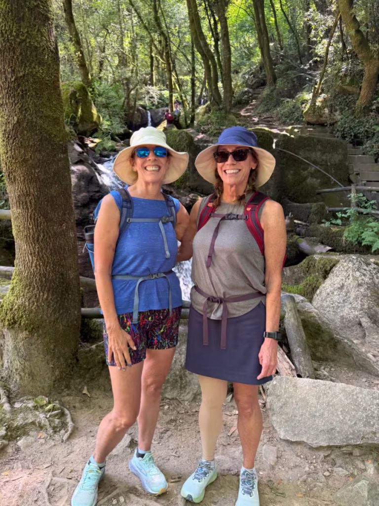 Two women in front of a waterfall.