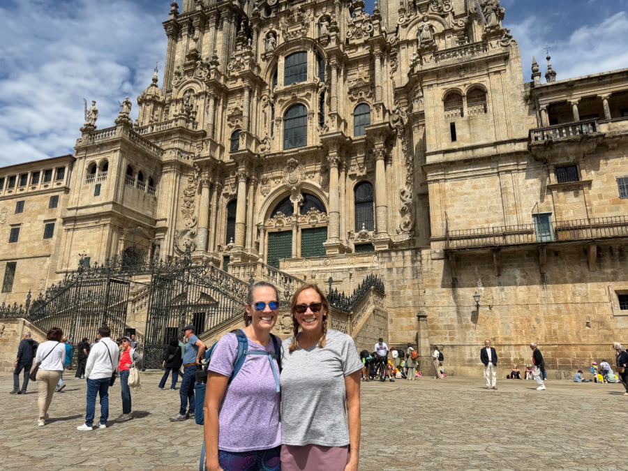 Two women standing in front of the Cathedral de Santiago.