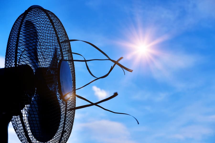 An electric fan under blue skies and sunshine.
